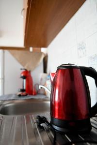 - Hervidor de té rojo sobre una estufa en Papi's Free Parking Apartments 2 - Studio, en Alexandroupoli