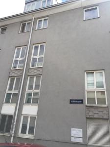 een grijs gebouw met ramen en een blauw bord erop bij No Smoking, Cozy Apartment in top location 15 min to Center in Wenen