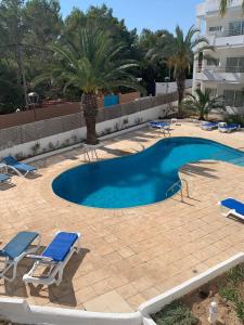 a swimming pool with lounge chairs and a resort at Appartamento Costamar 14, Es Pujols, ALTA TURISTICA in Es Pujols