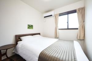 une chambre blanche avec un lit et une fenêtre dans l'établissement E-horizon Resort コンドミニアム名護E, à Nago 31 autres photos