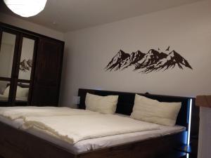 ein Schlafzimmer mit einem Bett mit Bergen an der Wand in der Unterkunft Ferienhof Kösel in Missen-Wilhams