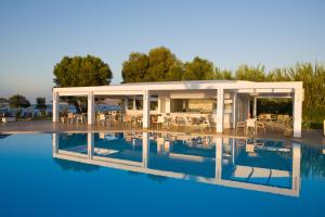 a villa with a pool in front of a house at Geraniotis Hotel and Resort in Platanias