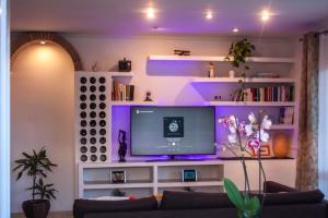 sala de estar con TV e iluminación púrpura en Casa con vistas al mar WI-FI BBQ AirCond, en Calafell
