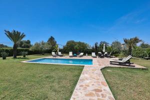 una piscina con tumbonas y sillas en un patio en Villa Kentia, charming and stylish country house close to Palma, sleep 8, en Palma de Mallorca