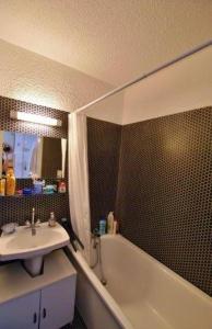 a bathroom with a sink and a bath tub and a sink at Appartements Barcelonette by PraLoup Vacances in Barcelonnette