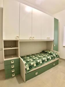 a bedroom with a green bed and white cabinets at Terrazza sul mare Pisciotta - Palinuro in Pisciotta