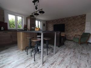 a kitchen with a bar with stools in a room at Gîte d’Alsace l’Escale in Ostheim