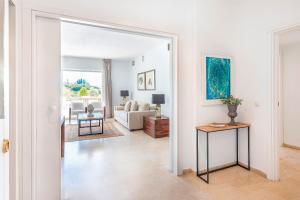 biały salon z kanapą i stołem w obiekcie Las Lomas de Marbella Club w Marbelli