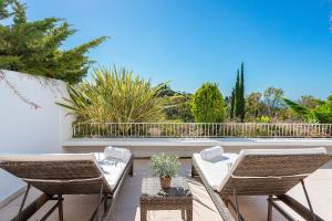 taras z dwoma krzesłami i stołem na balkonie w obiekcie Las Lomas de Marbella Club w Marbelli