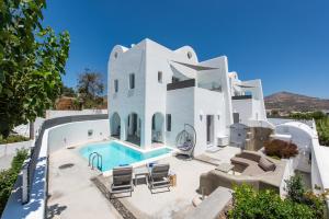 a large white house with a swimming pool at White Harmony Suites in Megalokhori