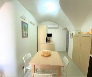 a dining room with a table and white chairs at La casetta in Noci
