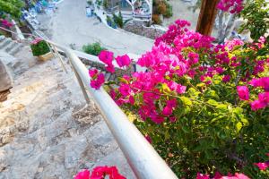 un ramo de flores rosas junto a una barandilla en Villa Mandraki, en Hydra