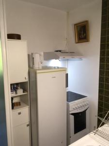 a small kitchen with a stove and a refrigerator at Les Pierrottes pour 2 in Mornac
