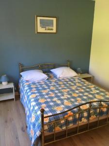 ein Schlafzimmer mit einem Bett mit einer Decke darauf in der Unterkunft Les Pierrottes pour 2 in Mornac