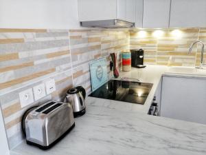 een keuken met een aanrecht met een broodrooster bij Le Piade, confort moderne, vue dégagée, clim, ascenseur, WiFi in Sète