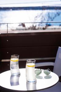 two glasses of water on a table in front of a window at George Hotel in Limenaria