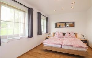 a bedroom with a bed with pink sheets and a window at Ferienwohnung In Techelsberg in Sankt Martin am Techelsberg