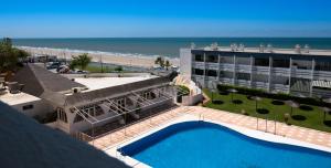 a view of a hotel with a swimming pool and the beach at Apartamentos Turisticos Flamero in Matalascañas