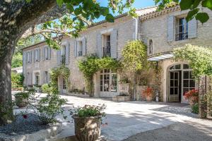 an old stone house with a courtyard with flowers at Hôtel Mas Valentine in Saint-Rémy-de-Provence