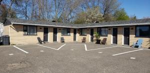 a parking lot in front of a building with chairs at Motel Lévis in Lévis