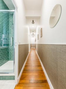 um corredor com uma cabina de duche ao nível do chão e um espelho em Edgar Suites Louvre - Saint-Honoré em Paris