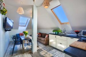 a kitchen and living room with a couch and a table at Apartament Bieszczadzkie Klimaty in Ustrzyki Dolne