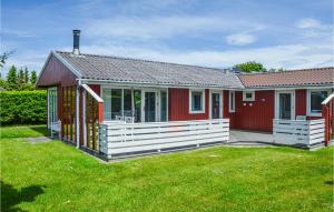 uma casa vermelha com uma cerca branca no quintal em Beautiful Home In Hemmet With Kitchen em Hemmet