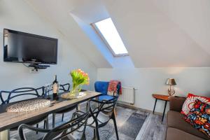 a living room with a table and chairs and a tv at Apartament Bieszczadzkie Klimaty in Ustrzyki Dolne