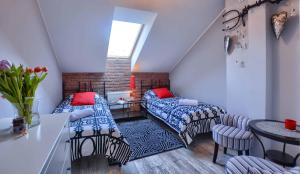 a attic room with two beds and a table at Apartament Bieszczadzkie Klimaty in Ustrzyki Dolne +28 photos