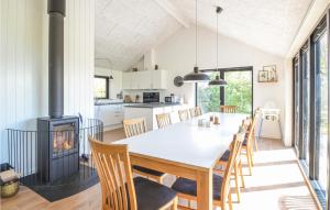 a kitchen and dining room with a table and a fireplace at Cozy Home In Vinderup With House Sea View in Vinderup