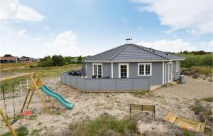 a tiny house with a slide and a playground at Cozy Home In Fan With Kitchen in Fanø