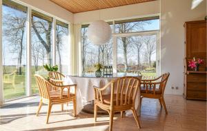 a dining room with a table and chairs and windows at Awesome Home In Holstebro With Kitchen in Holstebro