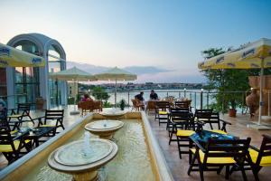 a restaurant with a pool of water and tables and chairs at Hotel Villa List in Sozopol