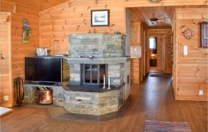 a living room with a stone fireplace and a flat screen tv at Gorgeous Home In Rn With Wifi in Ron