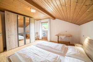 a bedroom with a large bed with a wooden ceiling at Greif - Apartment C in Verano