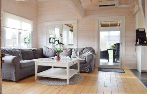 uma sala de estar com um sofá e uma mesa em Lovely Home In Frjestaden With Kitchen em Färjestaden