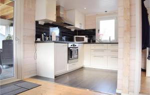 una cocina con armarios blancos y una pared negra en Lovely Home In Frjestaden With Kitchen en Färjestaden