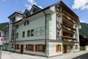 a white building with orange doors and windows at Apartment Villa Carolina in Kranjska Gora