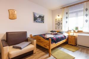 sypialnia z łóżkiem, krzesłem i oknem w obiekcie Apartamenty Zakopane Krupówki w Zakopanem