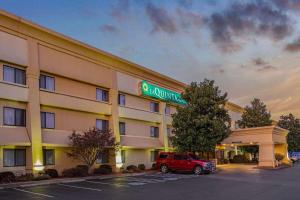 a hotel with a red car parked in a parking lot at La Quinta by Wyndham N Little Rock - McCain Mall in Little Rock