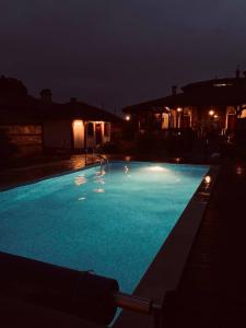 una gran piscina azul por la noche en Family Hotel Old Time, en Tyulenovo