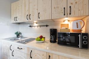 a kitchen counter with a bowl of fruit and a microwave at Apartamenty Zakopane Krupówki in Zakopane