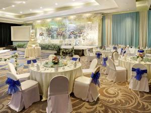 a banquet hall with white tables and white chairs at Mercure Convention Center Ancol in Jakarta +37 photos