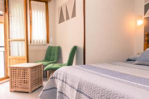 a bedroom with two green chairs and a bed at Hotel Plaza in Cangas de Onís +96 photos
