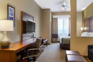 a hotel room with a desk and a bed at Comfort Inn & Suites in Amarillo