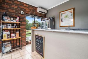 eine Bar in einem Restaurant mit einer Tafel an der Wand in der Unterkunft Comfort Inn Benalla in Benalla