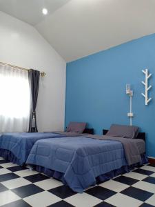 a blue bedroom with a bed and a blue wall at Pakdeehouse Homestay in Phra Nakhon Si Ayutthaya