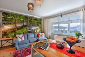 a living room with a blue couch in front of a mural at Apartament Zielona Mila in Ustrzyki Dolne