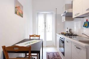 uma cozinha branca com uma mesa e um fogão em Bea Home sarai il benvenuto! em Roma
