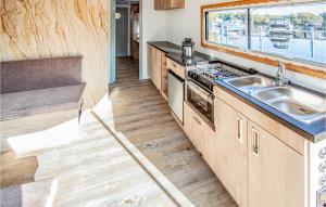 uma cozinha com um lavatório, um fogão e uma janela em Stunning Ship In Hennigsdorf With Lake View em Hennigsdorf